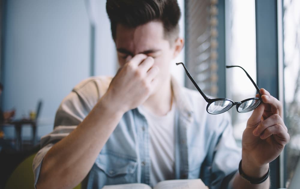 Young man taking a break from his glasses